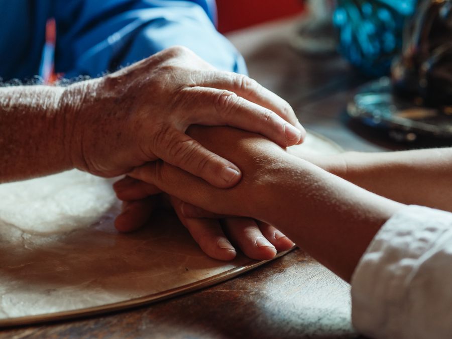 Clasped hands of an older and a younger person